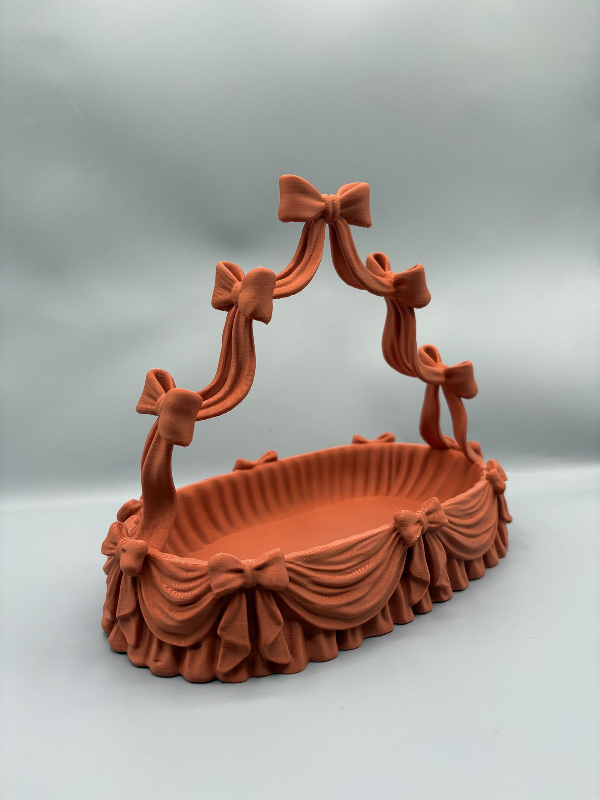 Coquette bow jewelry holder with an arched necklace stand over a scalloped catchall tray