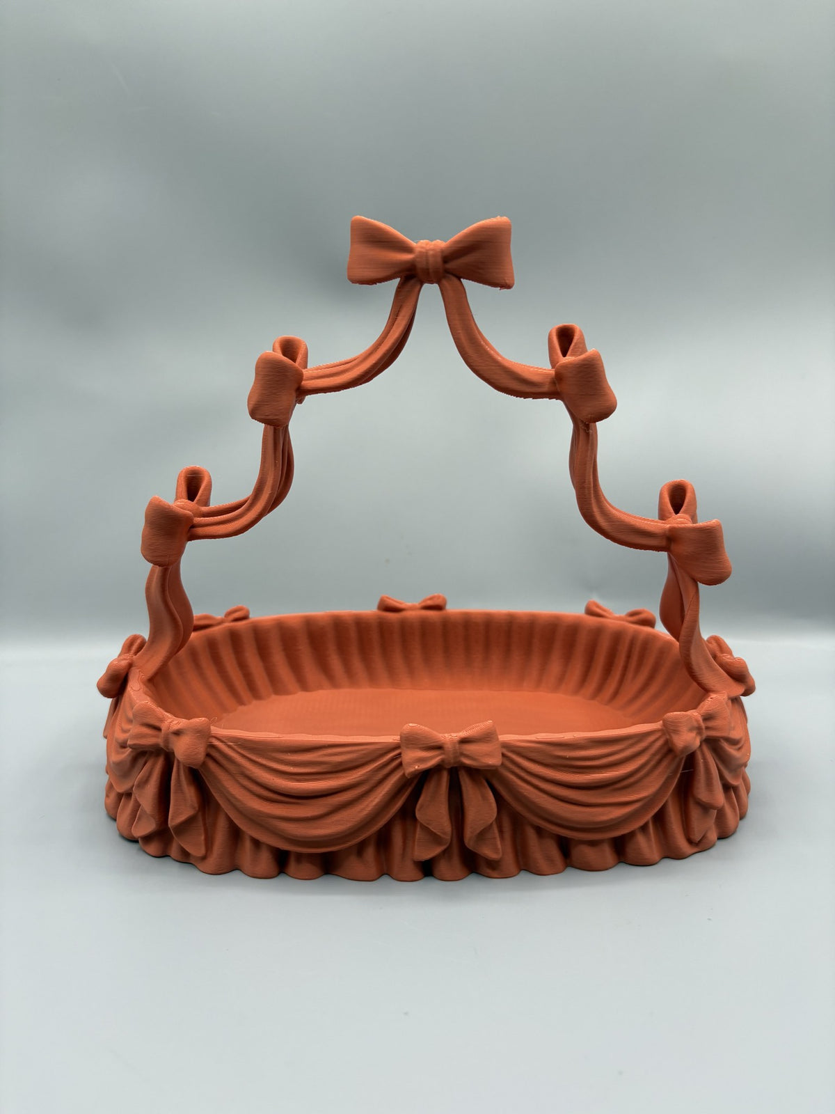Coquette bow jewelry holder with an arched necklace stand over a scalloped catchall tray