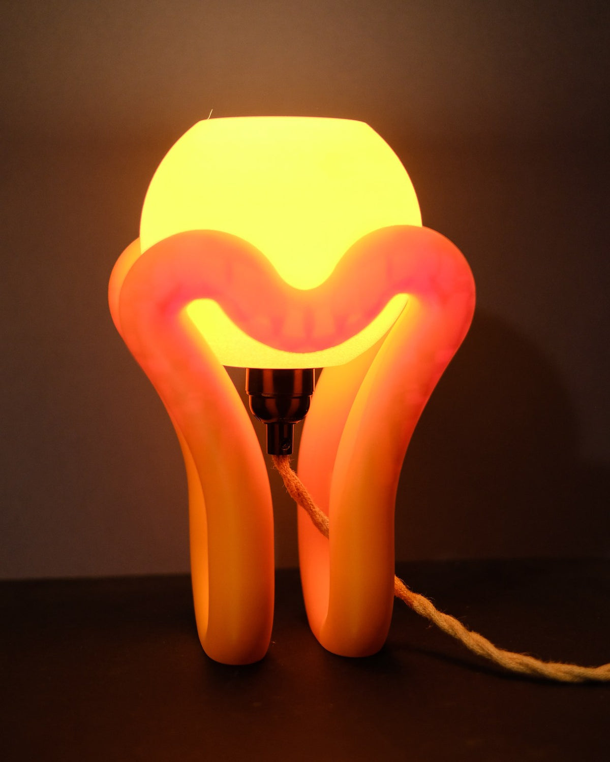 Floating wibble sphere table lamp glowing, orange stand cradling a lit sphere shade