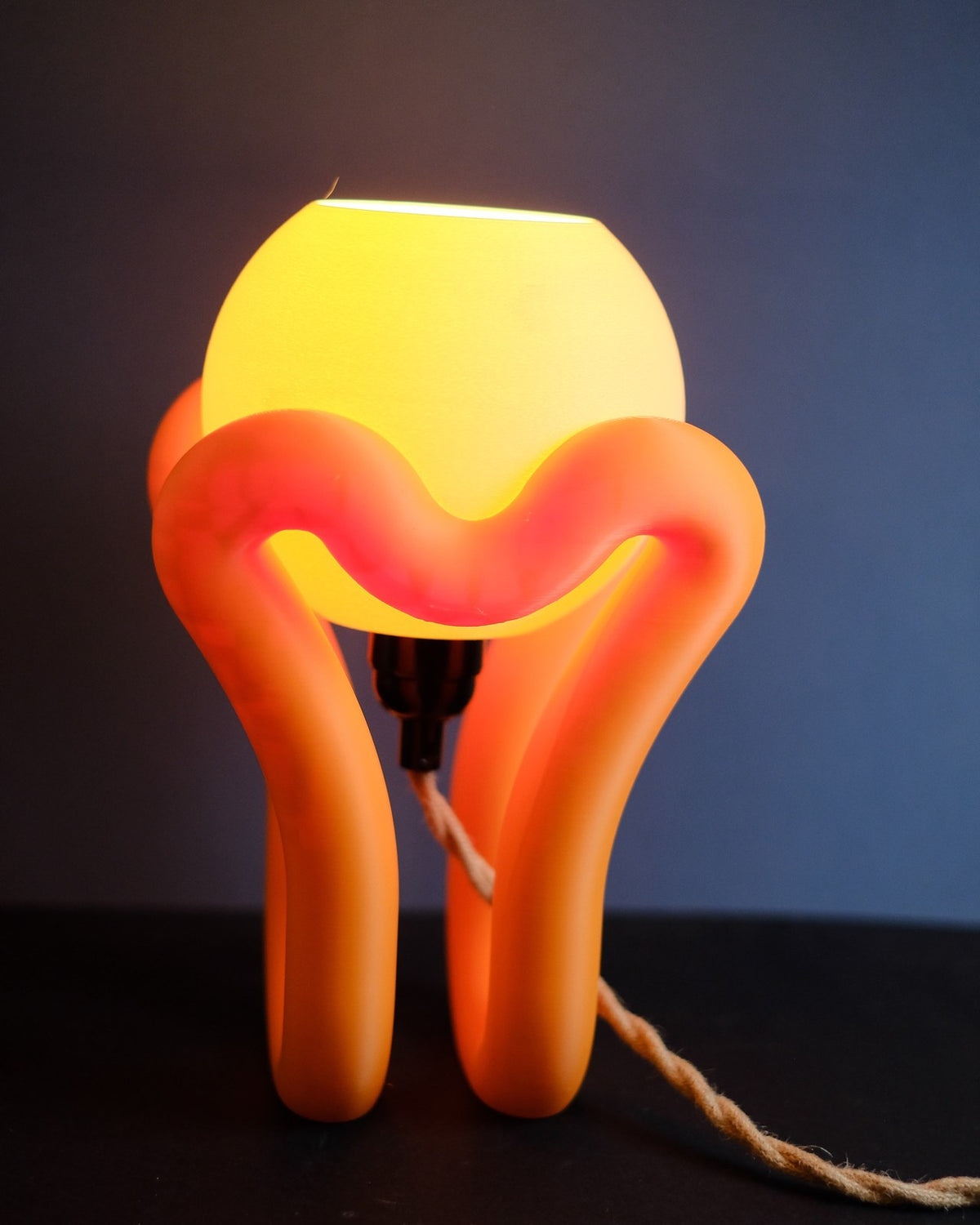 Floating wibble sphere table lamp lit, warm glow from the angled sphere shade