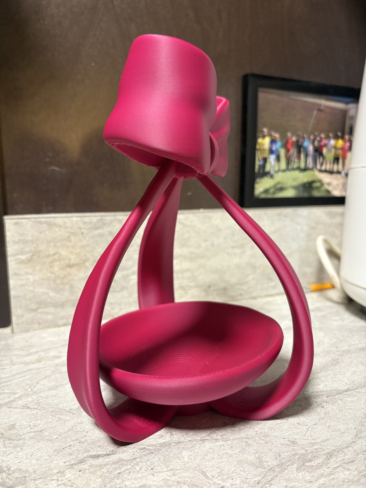Coquette bow jewelry dish, side view showing the ribbon loops arching over the dish