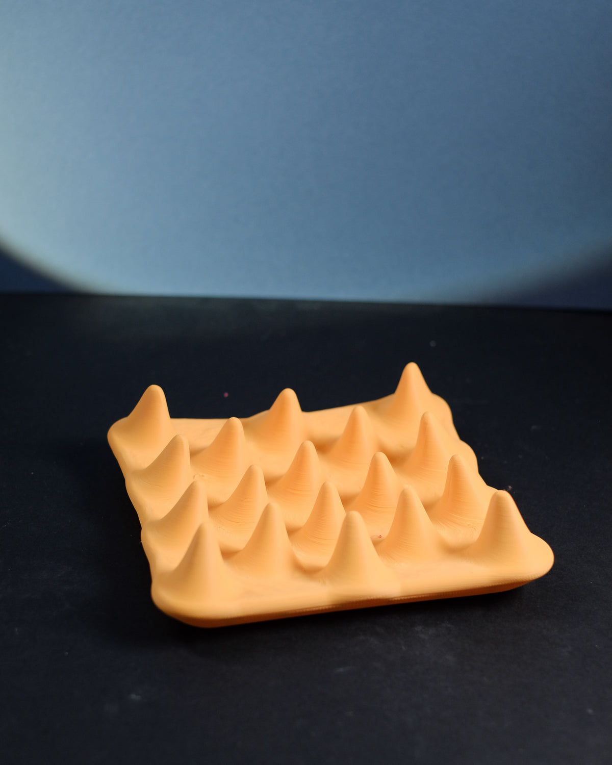 Spiked jewelry ring tray, three-quarter view showing the grid of rounded peaks